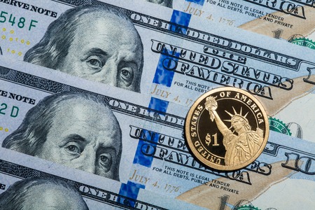 One dollar coin - The Statue of Liberty - on hundred dollars bills.の写真素材