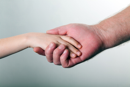 old man and kid holding hands togetherの写真素材