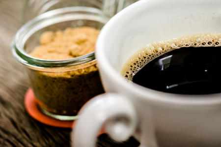 cup of black coffee, white and brown sugar on the wooden table backgroundの写真素材