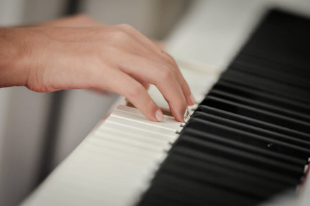 Hand playing on digital piano. Close-up. Small depth of field.