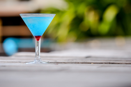 Frozen Blue Margarita Cocktail, blue cocktail on the wooden table, blurry backgroundの写真素材