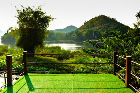 wooden sunbed on green artificial grass and looking the blue sky backgroundの写真素材