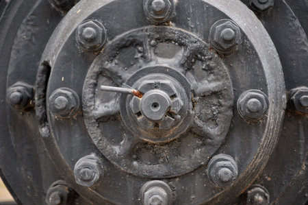old truck wheel nut, large wheel with eight lugs nuts on metallic iron with rust wheel surface with centre cap of a heavy duty vehicle transport bus and truckの写真素材