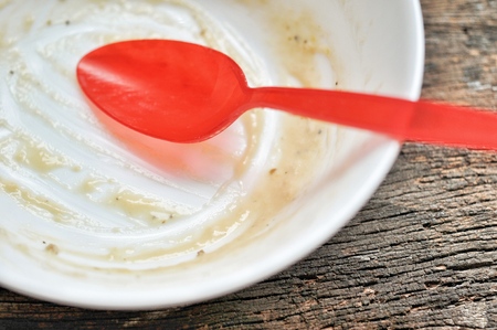 white bowl and red spoon after the finished the meal on the wooden table, dirty bowlの写真素材