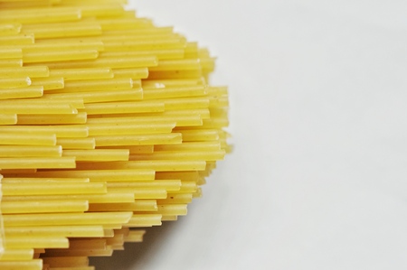 raw spaghetti pasta scattered on black old wooden table, close-up view from aboveの写真素材