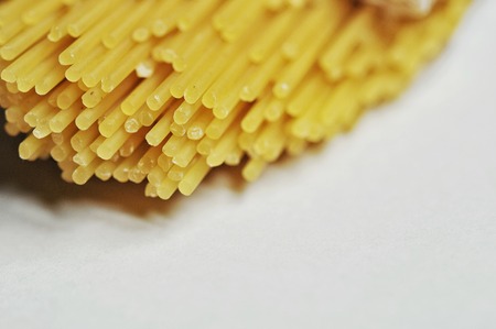 raw spaghetti pasta scattered on black old wooden table, close-up view from aboveの写真素材