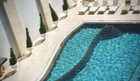 Water ripples on blue tiled swimming pool background, View from above, Aerial view of swimming pool outside hotel. Beautiful pool ready to holiday tourists.の写真素材