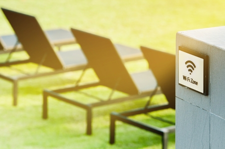Wireless internet sign on the wall near with sun bed on the grass field, relaxing and working business areaの写真素材