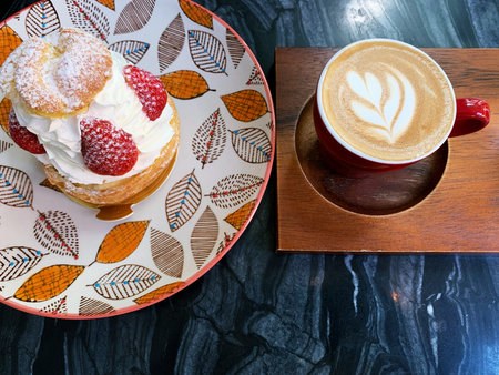 cup of cappuccino with latte art on wooden background. Beautiful foam, red ceramic cups, stylish...