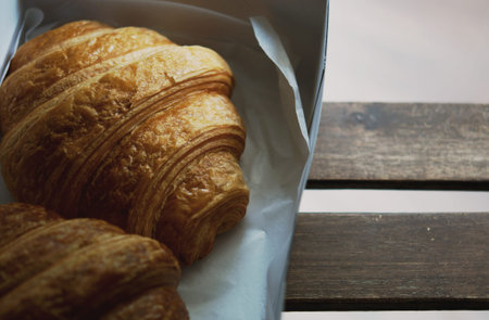 Plain butter croissants in eco friendly compostable disposable food container, plastic-free paper...