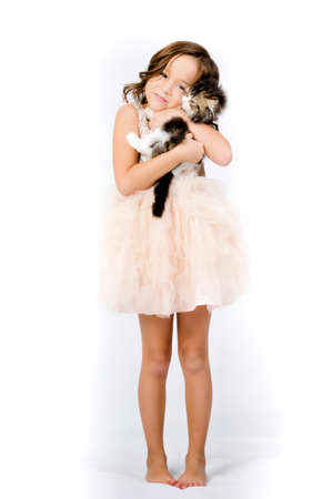 Portrait of happy pretty curly little girl standing and posing over white backgroundの写真素材