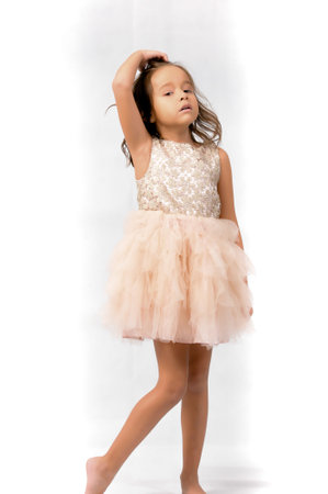 Portrait of happy pretty curly little girl standing and posing over white backgroundの写真素材