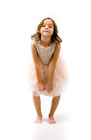 Portrait of happy pretty curly little girl standing and posing over white backgroundの写真素材