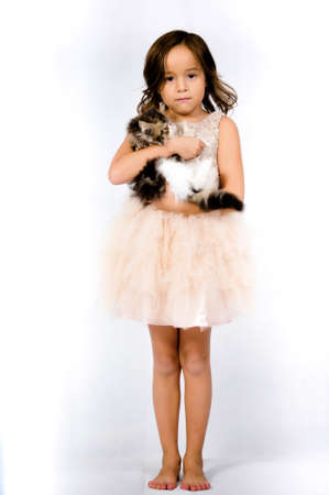 Portrait of happy pretty curly little girl standing and posing over white backgroundの写真素材
