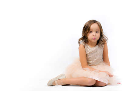 Portrait of happy pretty curly little girl standing and posing over white backgroundの写真素材