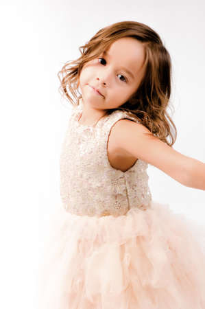 Portrait of happy pretty curly little girl standing and posing over white backgroundの写真素材