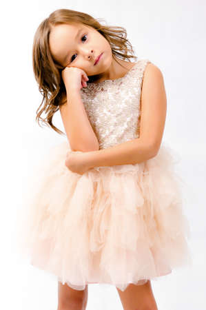 Portrait of happy pretty curly little girl standing and posing over white backgroundの写真素材