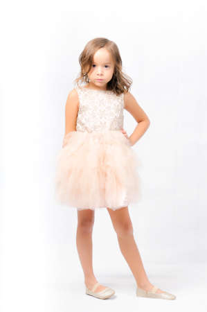 Portrait of happy pretty curly little girl wear Santa Claus dress and posing with Christmas decoration over white backgroundの写真素材