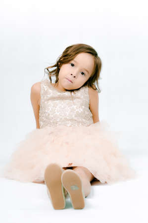 Portrait of happy pretty curly little girl wear Santa Claus dress and posing with Christmas decoration over white backgroundの写真素材