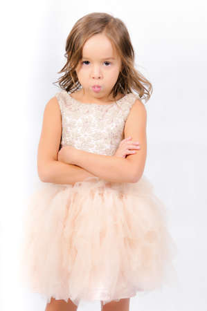 Portrait of happy pretty curly little girl wear Santa Claus dress and posing with Christmas decoration over white backgroundの写真素材