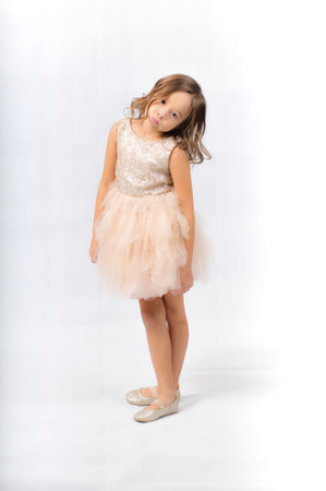Portrait of happy pretty curly little girl standing and posing over white backgroundの写真素材