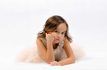 Portrait of happy pretty curly little girl standing and posing over white backgroundの写真素材