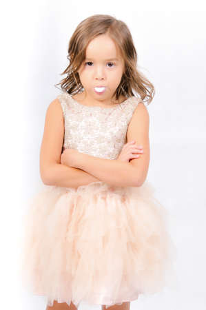 Portrait of happy pretty curly little girl standing and posing over white backgroundの写真素材