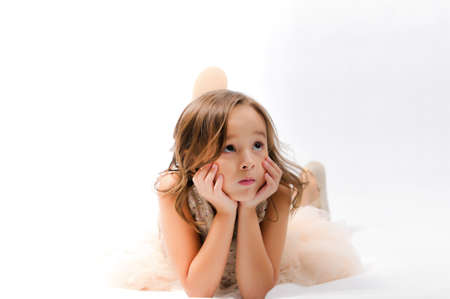 Portrait of happy pretty curly little girl standing and posing over white backgroundの写真素材