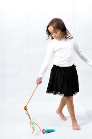 Portrait of happy pretty curly little girl standing and posing over white backgroundの写真素材