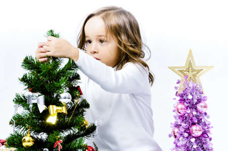 Portrait of happy pretty curly little girl wear Santa Claus dress and posing with Christmas decoration over white backgroundの写真素材