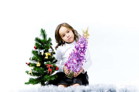 Portrait of happy pretty curly little girl wear Santa Claus dress and posing with Christmas decoration over white backgroundの写真素材