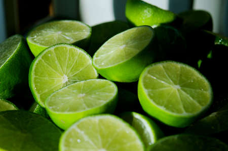 Lime Background with sun light from outside. Close up shot of limes. Selective Focus of sliced lime. Lime is a kind of fruit. The result is very sour for cook the Thai food styleの写真素材