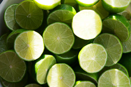 Lime Background with sun light from outside. Close up shot of limes. Selective Focus of sliced lime. Lime is a kind of fruit. The result is very sour for cook the Thai food styleの写真素材