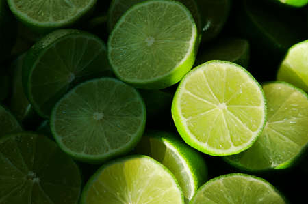 Lime Background with sun light from outside. Close up shot of limes. Selective Focus of sliced lime. Lime is a kind of fruit. The result is very sour for cook the Thai food styleの写真素材