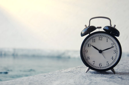 Alarm clock on the background of the sea. Time concept.の写真素材