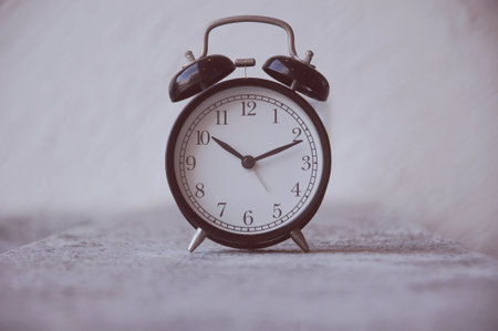 Vintage alarm clock on a gray background. Black and white image.の写真素材
