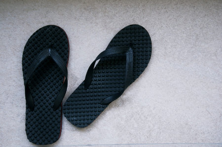 Black flip flops on a gray background. Top view, copy space.の写真素材