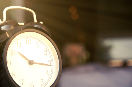 Retro alarm clock on blurred background, closeup. Space for textの写真素材