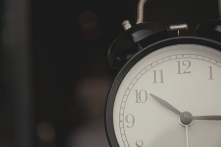 Retro alarm clock on dark background, closeup. Space for textの写真素材
