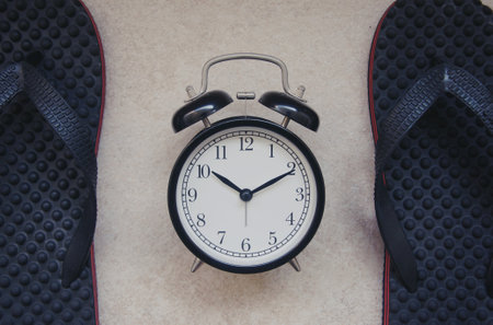 Alarm clock and sport shoes on brown background. Top view.の写真素材