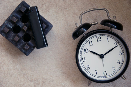 Alarm clock and brick on the table. Time management concept.の写真素材