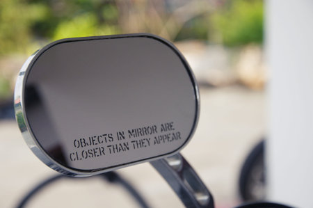 Rear view mirror with warning text objects in mirror are closer than they appear, reflecting road, left side lateralの写真素材