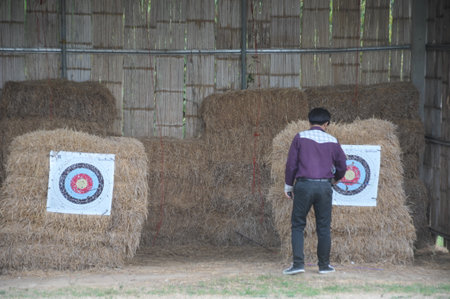 A man is shooting a target with a gun in the field.の写真素材