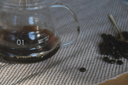 coffee in glass teapot and coffee beans on the tableの写真素材