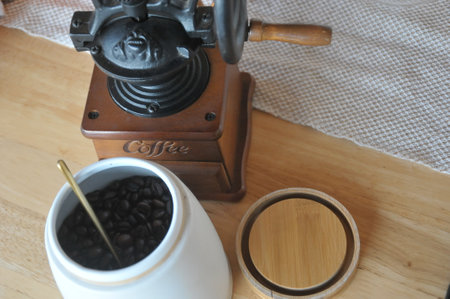 Coffee grinder and coffee beans on a wooden table.の写真素材