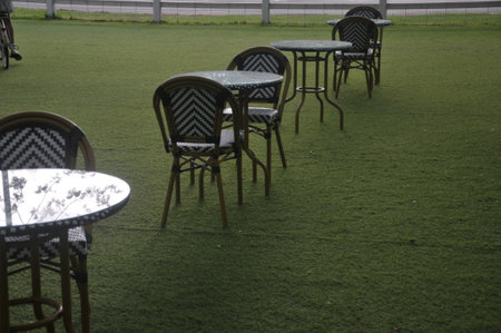 Table and chairs in a cafe on the green grass in the parkの写真素材