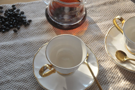 Cup of coffee with teapot and coffee beans on tableの写真素材