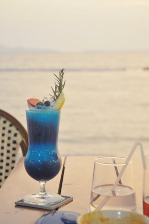Blue Curacao Cocktail on table with sea view background.の写真素材