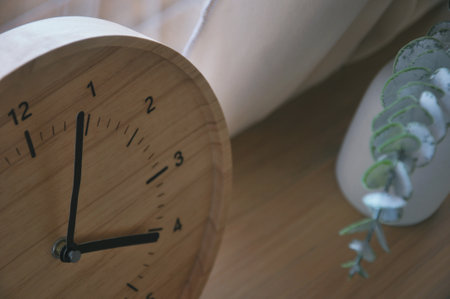 Alarm clock and sneakers on the wooden table in the morning.の写真素材