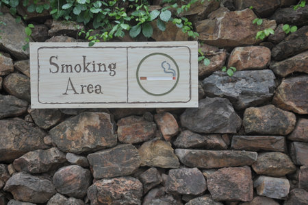 Smoking area sign on a stone wall, with copy space.の写真素材
